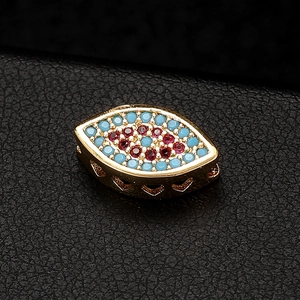 Ethnic gold evil eye charm with blue and red zircons and side heart cutouts