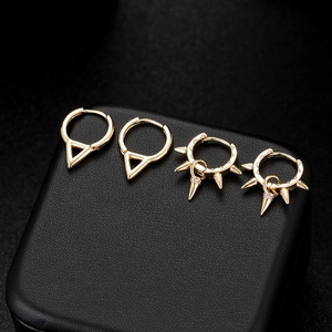 Punk style gold spike and geometric hoop earrings on black leather display box