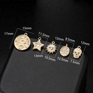 Macro detail of 14K gold-plated star and evil eye charms with cubic zirconia for DIY