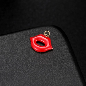 Creative red lip enamel pendant with golden accents on a luxury black leather base