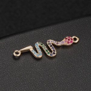 Dettaglio macro del connettore a serpente dorato con cristalli colorati e doppi anelli