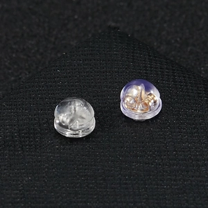 Détail macro de fermoirs en silicone avec noyau doré sur fond de texture noire