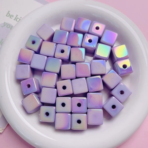 Macro detail of 14mm iridescent purple cube beads with central holes for DIY jewelry