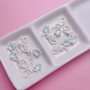Detailansicht der weißen Schleifen- und Sternanhänger mit AB-Zirkon für DIY-Schmuck