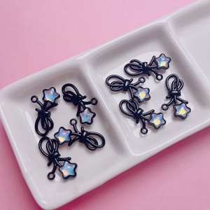 DIY-Zubehör mit schwarzer Schleife und schillernder Sternperle auf einer Keramikschale