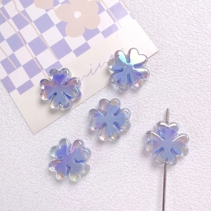Detalle macro de cuentas de trébol de cuatro hojas irisadas azul-púrpura para joyería DIY