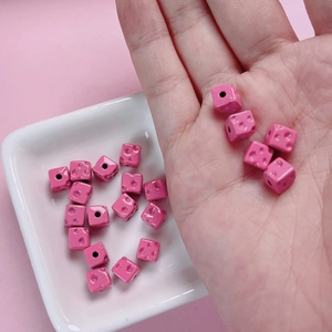 7mm pink cheese cube dice beads for DIY jewelry making displayed on a small white plate