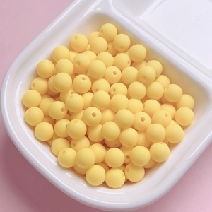 Macro detail of 6mm yellow matte rubber-coated round beads for DIY jewelry making