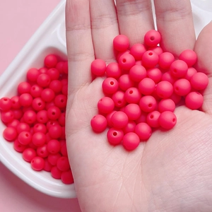 Detailed macro view of 8mm matte red rubber beads with center holes for DIY jewelry