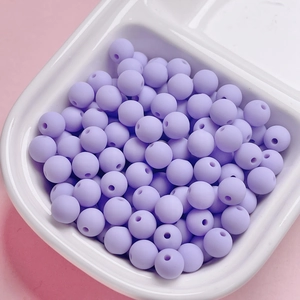 Close-up of matte lavender round beads for DIY jewelry making in a white tray