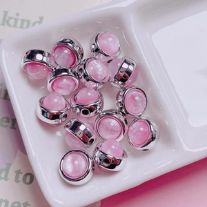 Detailed view of pink cat eye beads with silver metal base for DIY jewelry making