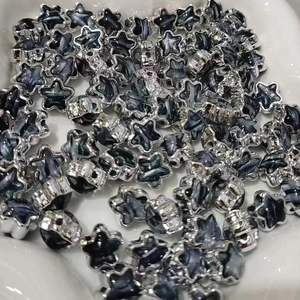 Close-up of star-shaped acrylic beads with silver edges and black marble texture