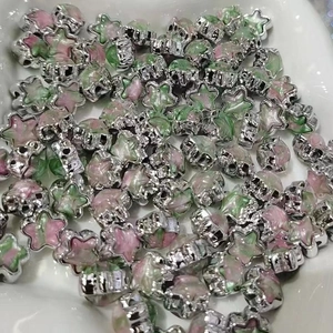 Macro shot of star-shaped acrylic beads with silver edges and pink-green gradient for DIY