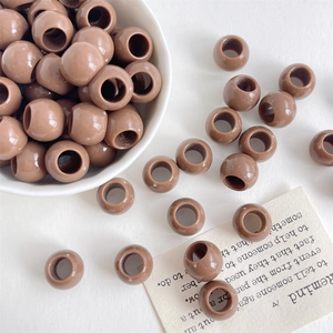 Nahaufnahme von braunen 12mm Harzperlen mit großem Loch in einer Schale für DIY-Schmuck