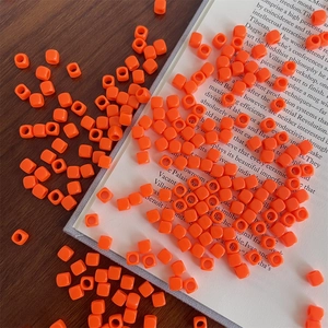 Macro detail of orange acrylic macaron square beads for DIY jewelry and phone chains