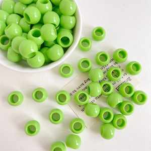 Makro-Detail von glänzenden hellgrünen 12mm Perlen mit großem Loch für DIY Schmuck