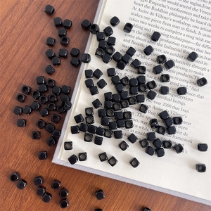 Close-up of glossy black square acrylic spacer beads with large holes for DIY jewelry making