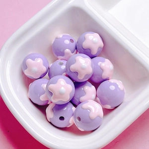 Detailed view of pink and purple floral acrylic beads for DIY jewelry making