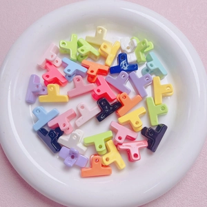 Kleurrijk assortiment mini-haarklemmetjes van acryl in een witte keramische schotel