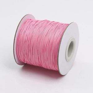 Vista macro de carrete de cordón de algodón encerado rosa para hacer joyas y artesanías