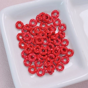 Macro detail of red alloy wave beads with white polka dots for DIY jewelry making