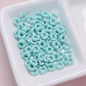 Close-up of Tiffany blue flower-shaped spacer beads in a white jewelry organizer tray