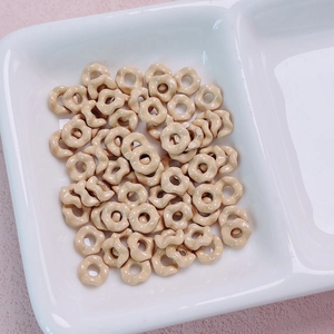 Macro view of light brown wave-edged spacer beads for DIY jewelry making in a white tray