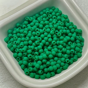 Green rubber-finish round beads for DIY jewelry and necklaces in a white tray