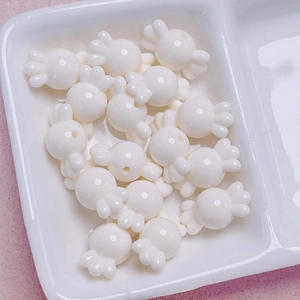 Vista macro de cuentas de acrílico blanco con forma de caramelo para joyería DIY