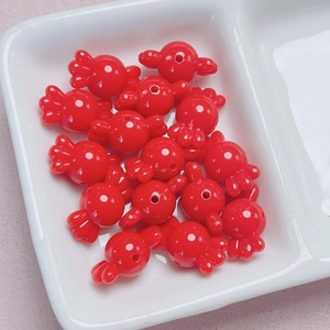Primer plano de cuentas acrílicas rojas con forma de caramelo para joyería artesanal
