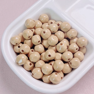 Close-up of 10mm glossy light brown acrylic beads with holes for DIY jewelry making