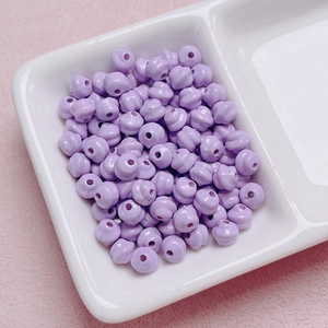Dettaglio di perle a spirale in acrilico lavanda con foro centrale per creazione gioielli