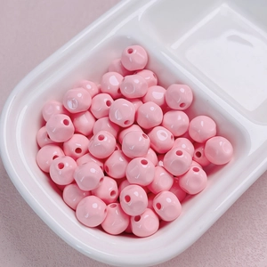 Macro detail of 10mm glossy pink acrylic beads for DIY jewelry and phone chains