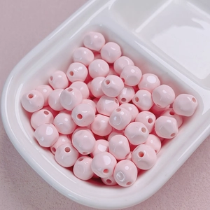 Macro detail of 10mm glossy pink acrylic beads with center hole for DIY jewelry making