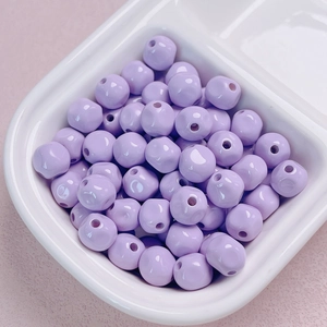 Close-up of 10mm lavender purple acrylic lacquer beads in a ceramic tray for DIY jewelry