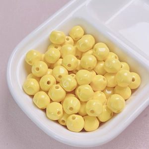 Close-up of 10mm bright yellow acrylic beads with glossy finish and center hole for DIY