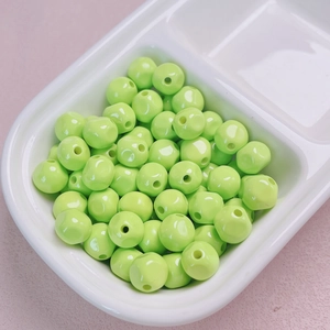 Macro shot of bright neon green 10mm acrylic beads for DIY jewelry and phone chains