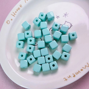 Macro shot of 12mm mint green acrylic square spacer beads for DIY jewelry making