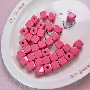 Macro detail of 12mm pink acrylic square beads with vertical holes for DIY jewelry making