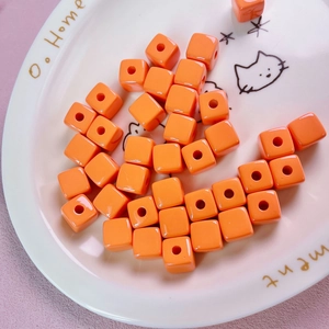 Macro detail of 12mm orange acrylic square beads for DIY jewelry and phone chains