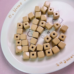 Close-up of 12mm light brown acrylic cube beads with holes for DIY jewelry making