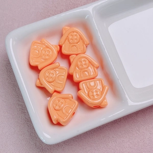 Close-up of 6 cute orange house-shaped acrylic beads with smiley faces for DIY jewelry