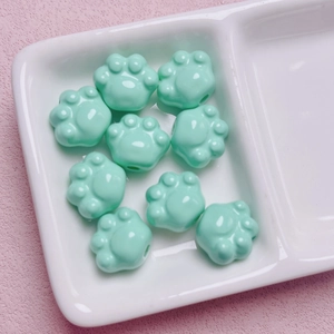 Detalle macro de cuentas de garra de gato de acrílico verde menta para joyas DIY