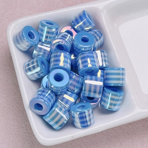 Colorful UV plated resin striped cylinder beads for DIY jewelry making in a white ceramic tray