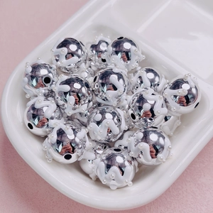 Primer plano de cuentas DIY plateadas con esmalte blanco e incrustación de perlas falsas