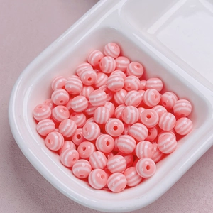 Dettaglio di perline rotonde a strisce rosa e bianche per la creazione di gioielli DIY