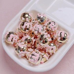 Detalle macro de cuentas m de esmalte rosa y oro con detalles de perlas para joyas DIY