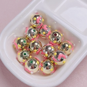 Detalle de cuentas de joyería DIY acabado dorado ondas rosas y pedrería brillante