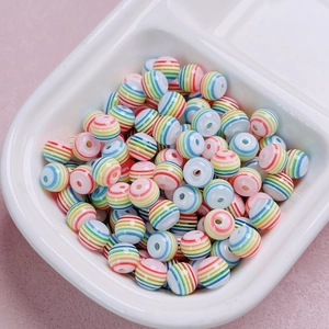 Dettaglio di perle acriliche rotonde a strisce arcobaleno per gioielli fai da te