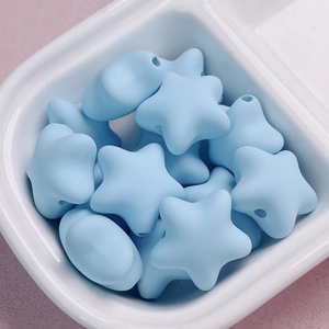 Macro detail of light blue matte acrylic star beads with central hole for DIY jewelry